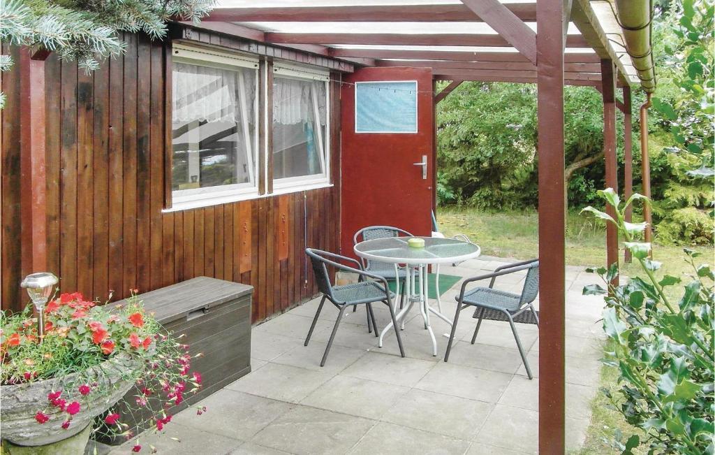patio ze stołem, krzesłami i czerwonymi drzwiami w obiekcie Beautiful Home In Trassenheide With Kitchen w Trassenheide