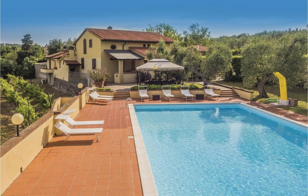 a swimming pool with chairs and a house at Villa Doveri Ceppeto in Forcoli