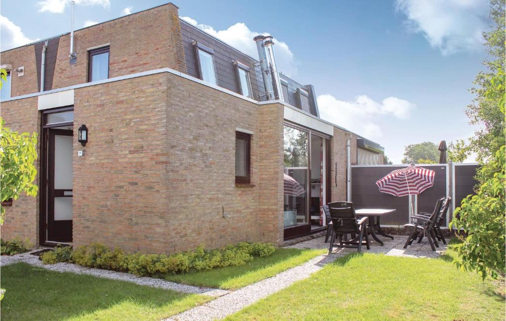 a brick house with a table and chairs in the yard at Beautiful Home In Nieuwvliet-Bad in Nieuwvliet-Bad