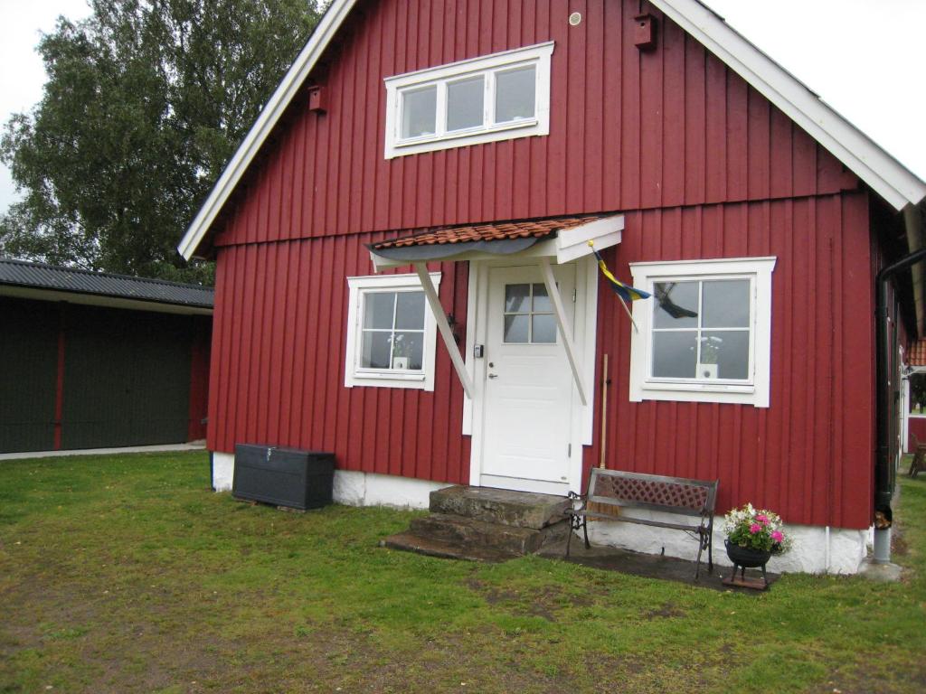a red house with a bench in front of it at Stixered Fegen in Fegen