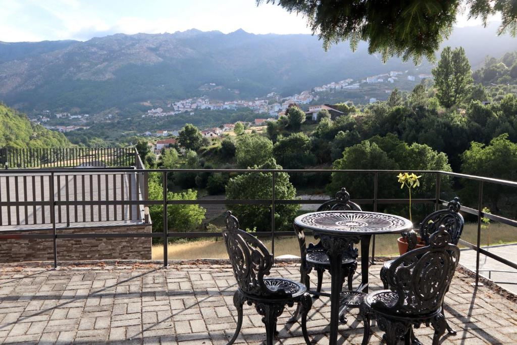 una mesa y sillas en un patio con vistas a la montaña en Alojamento Santa Clara, en Manteigas