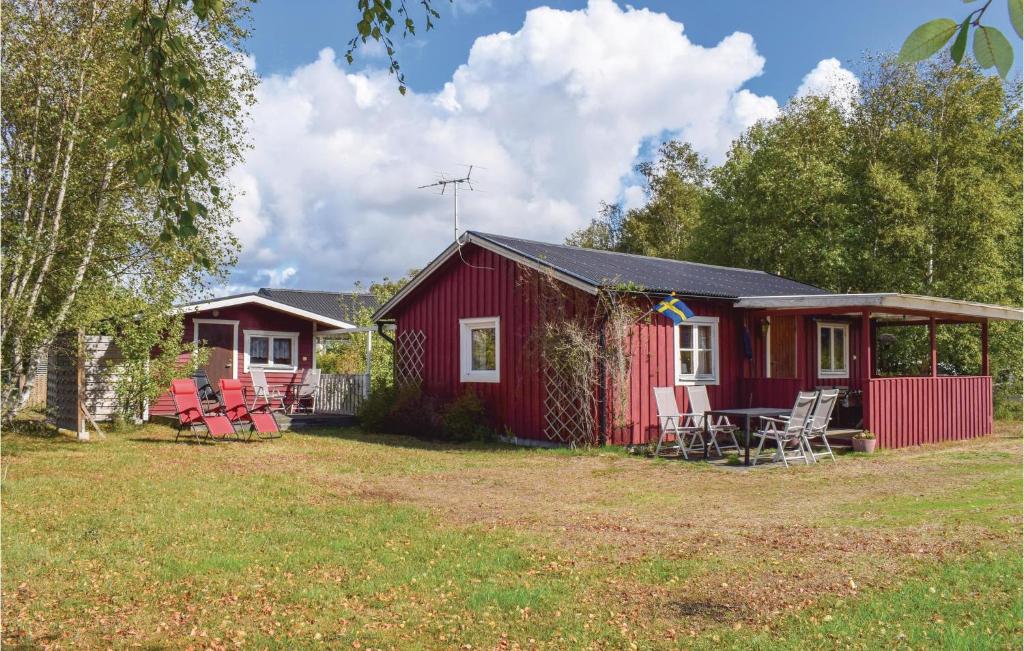 une cabine rouge avec des chaises et une table dans une cour dans l'établissement Beautiful Home In Skummeslv With Kitchen, à SkummeslÃ¶v