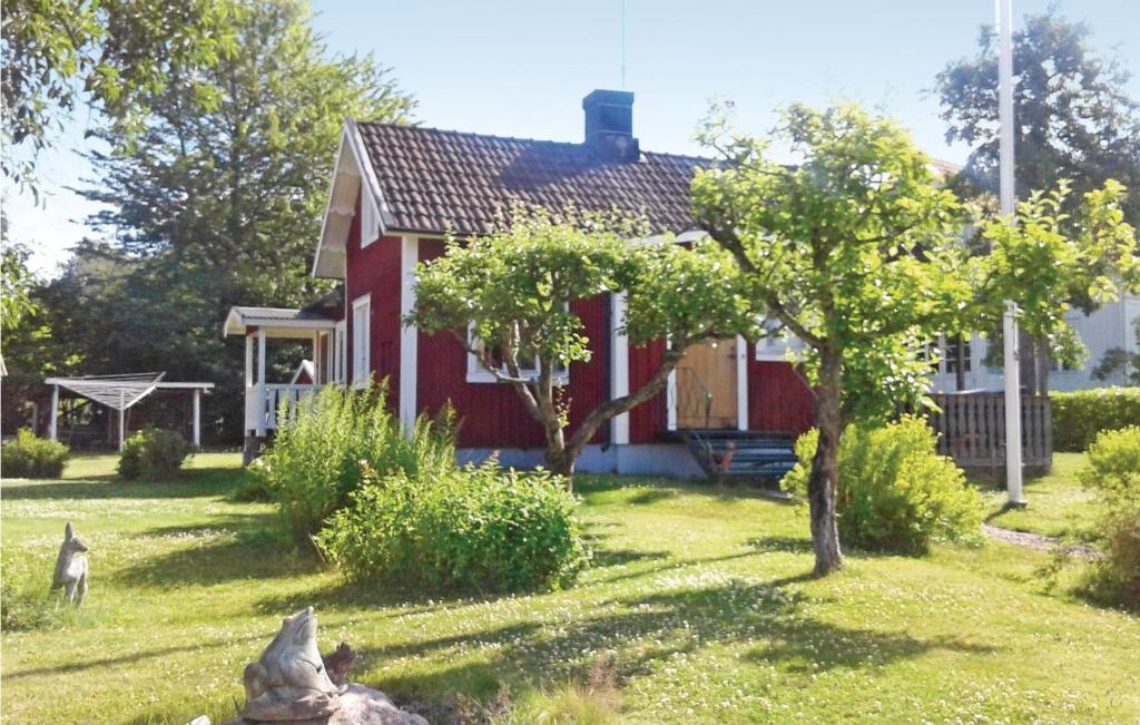 a red house with a dog in front of it at Awesome Home In Sjtorp With Wifi in Sjötorp
