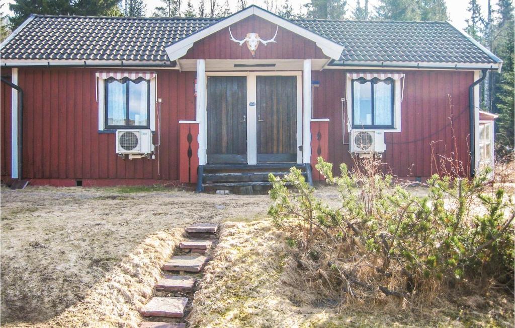 a red house with a red door and windows at Nice Home In Transtrand With Sauna And Wifi in Transtrand