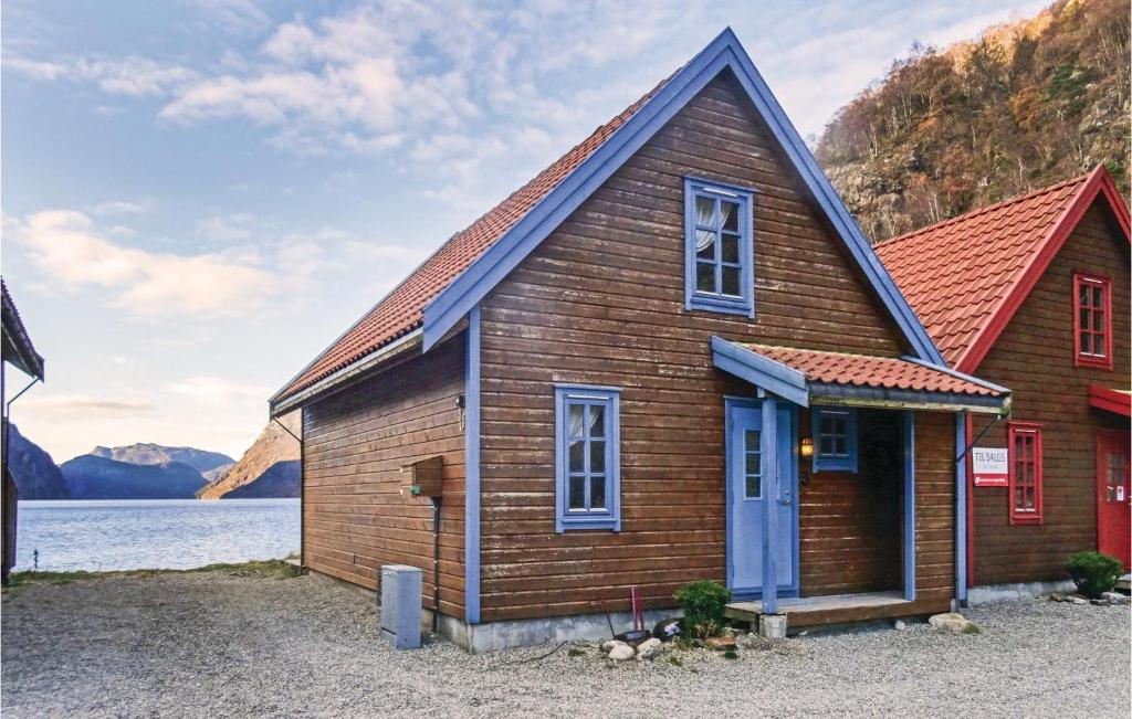 una piccola casa in legno con tetto rosso di Nice Home In Dirdal With Kitchen a Dirdal