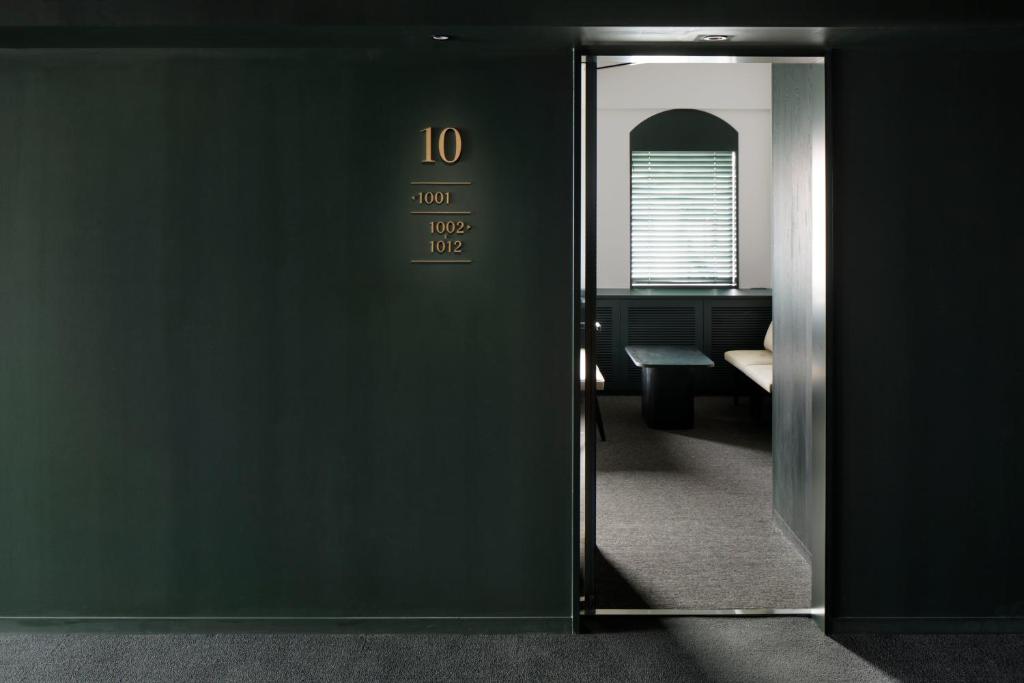 una porta aperta per una camera con specchio di DDD HOTEL a Tokyo