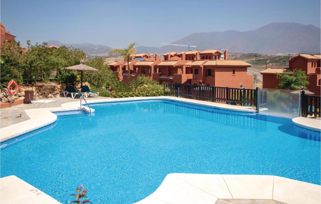 una gran piscina azul con edificios al fondo en Beautiful apartment in Estepona with 3 Bedrooms, Outdoor swimming pool and Swimming pool, en Estepona