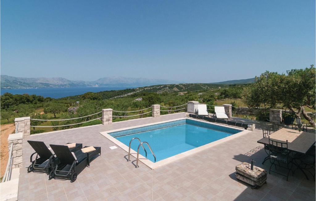 - une piscine avec des chaises et une table sur la terrasse dans l'établissement Lovely Home In Postira With House Sea View, à Postira