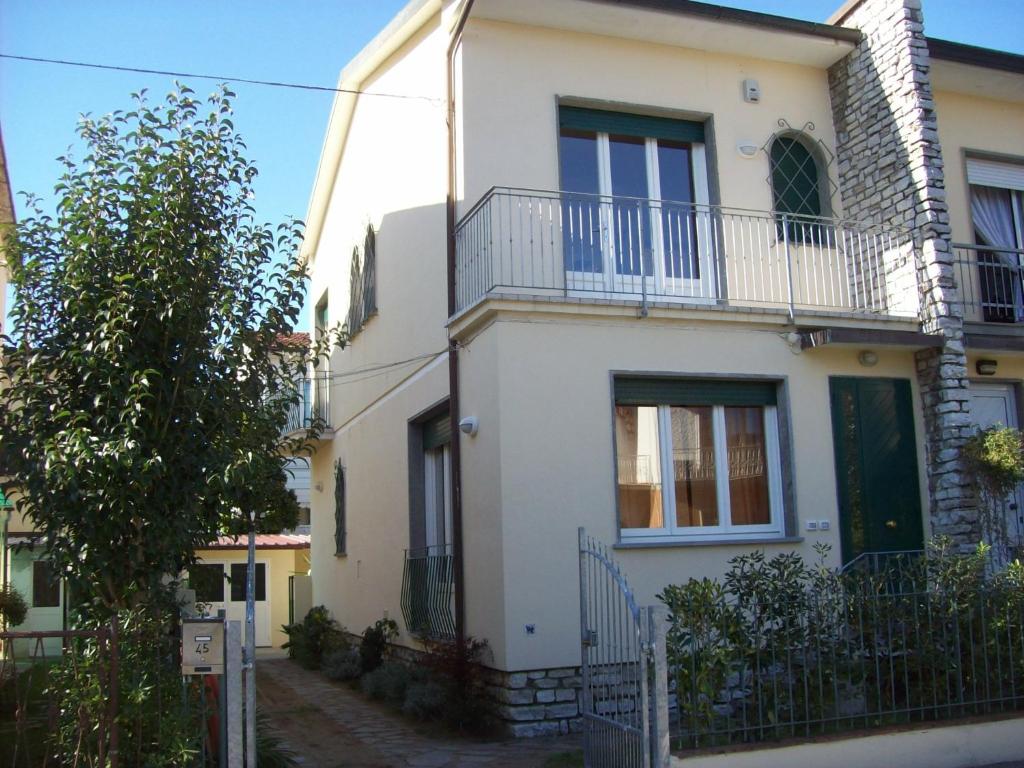 uma casa branca com uma cerca à frente. em Il Mirto em Viareggio