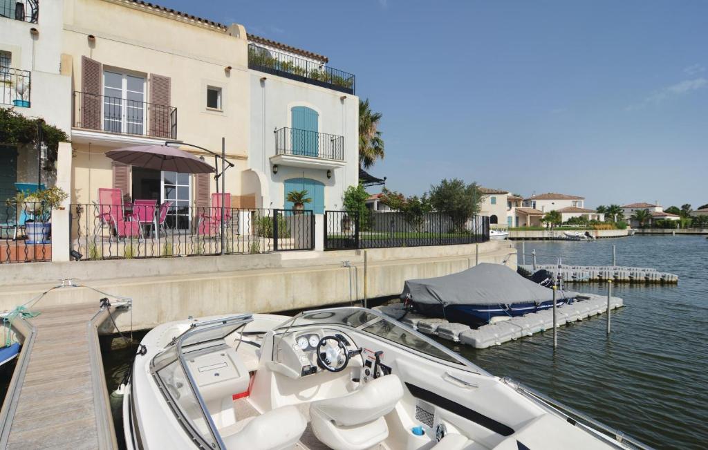 un bateau amarré à un quai à côté d'un bâtiment dans l'établissement 3 Bedroom Nice Home In Aigues-Mortes, à Aigues-Mortes
