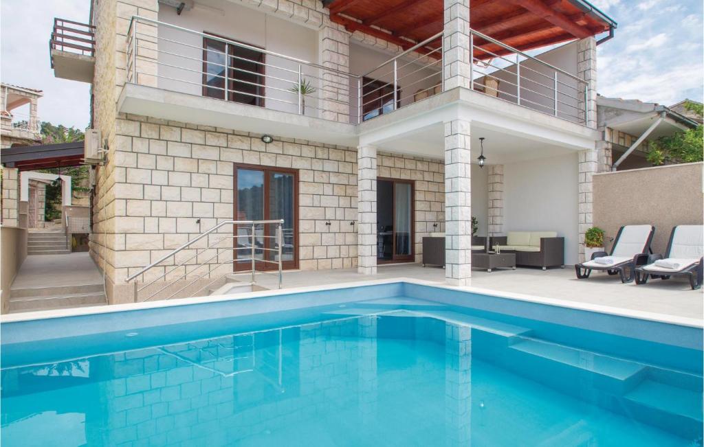 a swimming pool in front of a house at Amazing Home In Brna With 5 Bedrooms, Wifi And Outdoor Swimming Pool in Brna