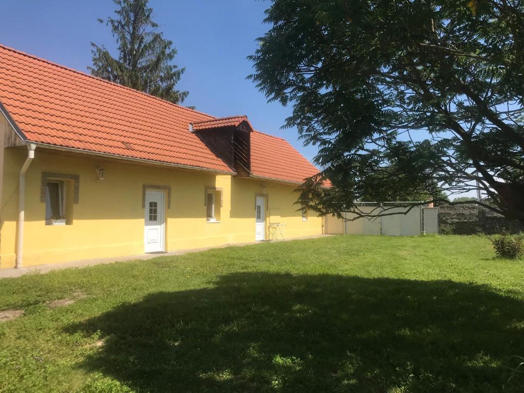 ein gelbes Haus mit rotem Dach und einem Hof in der Unterkunft U Pichlerů in Klipec