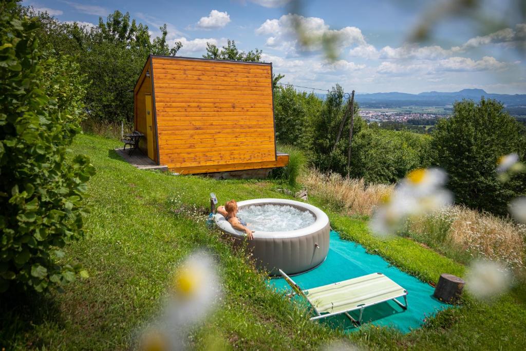 a tub in the grass next to a cabin at Panorama Glamping Visole in Slovenska Bistrica
