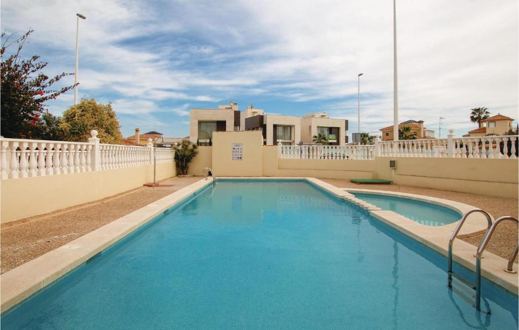 プレヤス・デ・オリフエラにあるStunning Home In Orihuela With Outdoor Swimming Poolの白いフェンス付きの青い大型スイミングプール