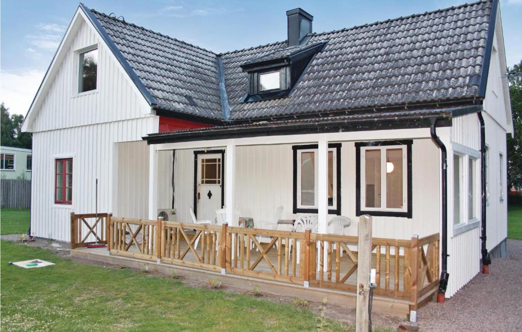 une maison blanche avec une terrasse en bois dans l'établissement 2 Bedroom Stunning Home In Hr, à Höör