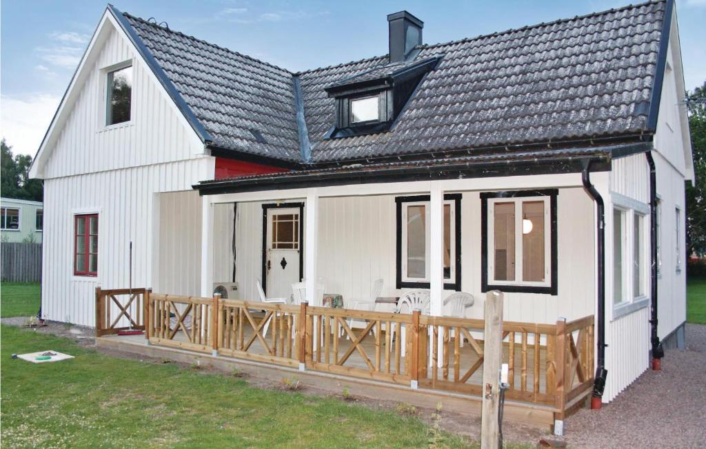 a white house with a wooden deck at Holiday Home Björkvägen Höör in Höör