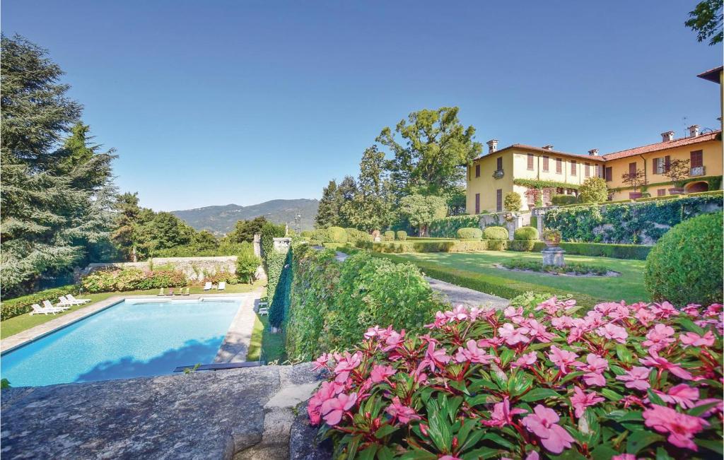 a garden with a swimming pool and pink flowers at Villa Ghislanzoni in Calco