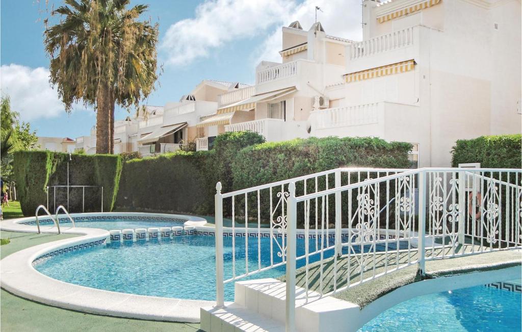 een zwembad voor een wit gebouw bij Amazing Apartment In Guardamar Del Segura With 2 Bedrooms, Wifi And Outdoor Swimming Pool in Guardamar del Segura