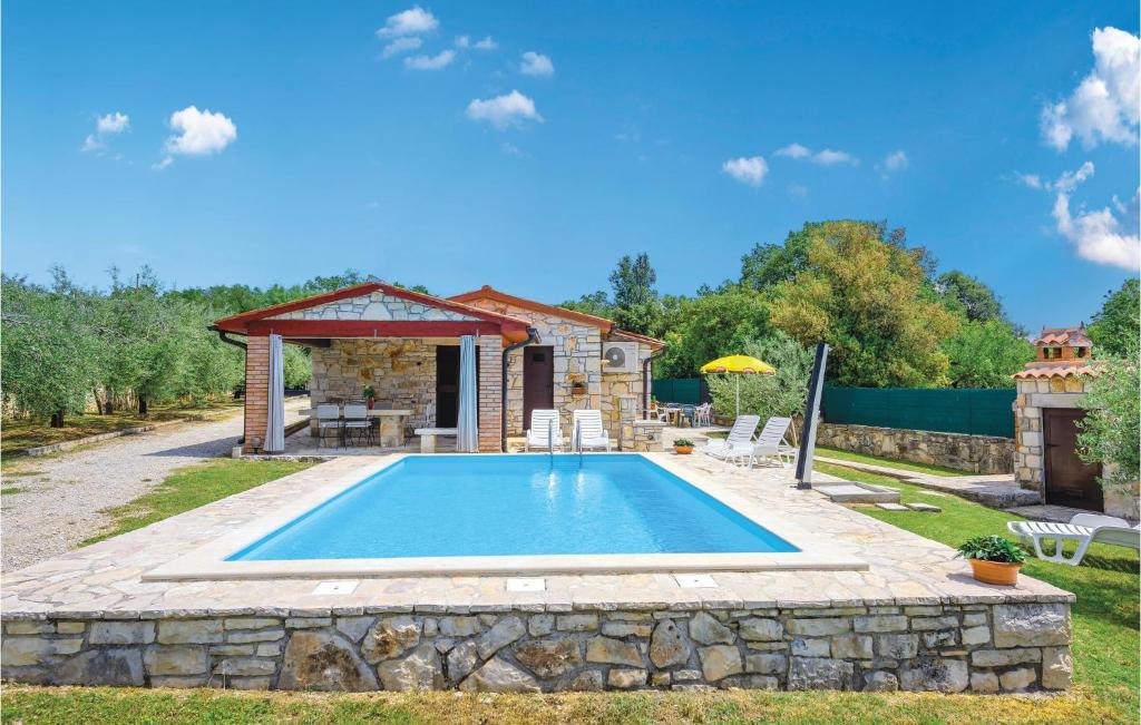 a swimming pool in a yard with a house at Amazing Home In Rovinj With 2 Bedrooms And Outdoor Swimming Pool in Spanidiga