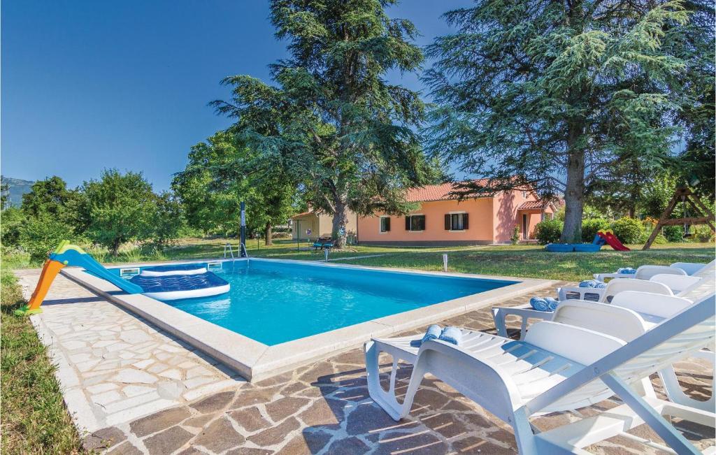 a pool with chairs and a slide in a yard at Beautiful Home In Krsan With Wifi in Kršan