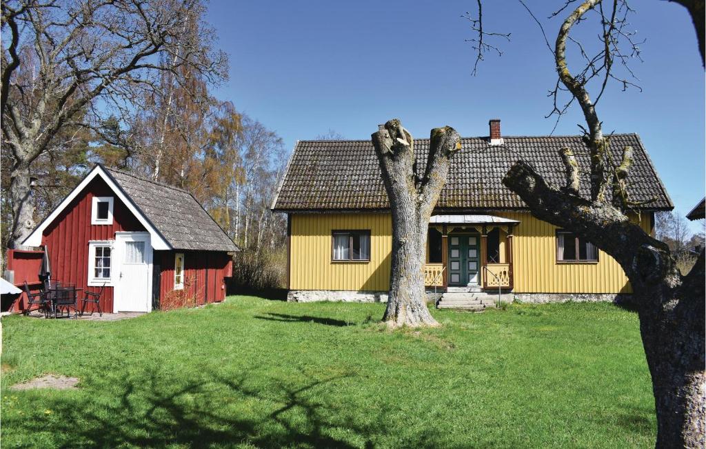 a red and yellow house with a tree in the yard at 3 Bedroom Beautiful Home In Lttorp in Löttorp