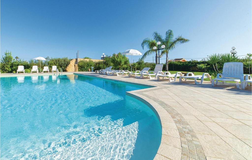 a large swimming pool with chairs at Mathia in Case Campanella