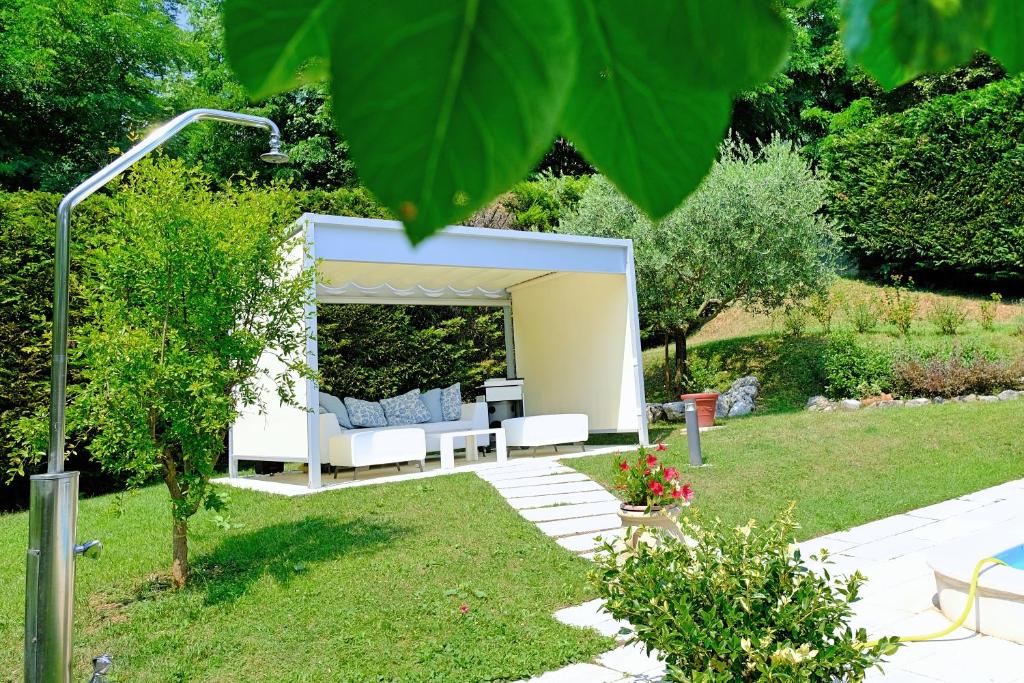 a garden with a white couch under a canopy at RosArancio in Bassano del Grappa