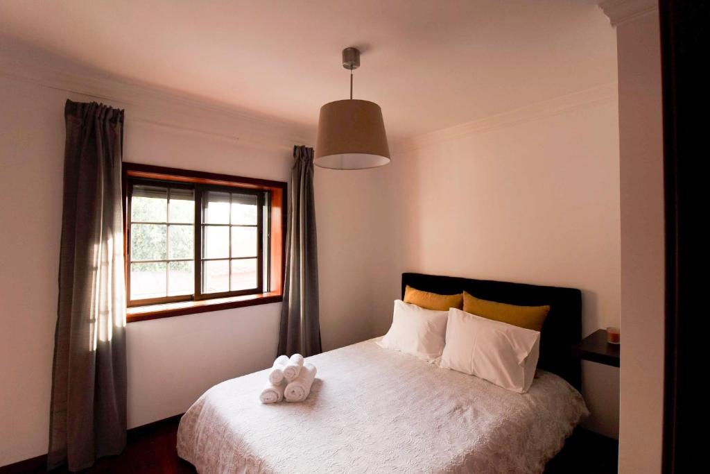 um quarto com uma cama com um urso de peluche em A Ilha do Lindo Vale no Porto