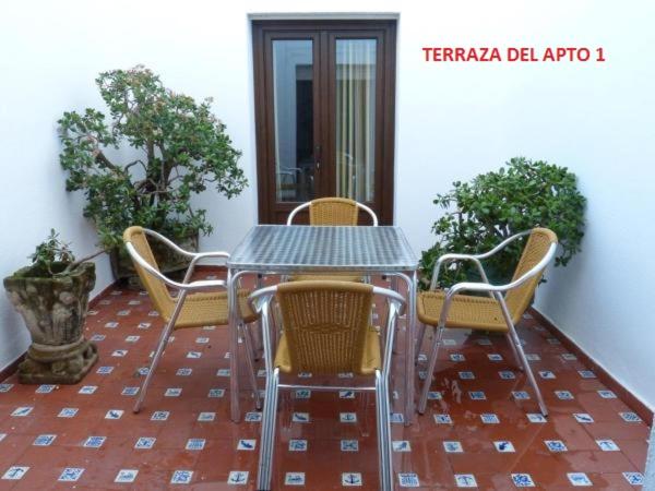 una mesa y sillas en un patio en Casa del Sol en Zahara de los Atunes