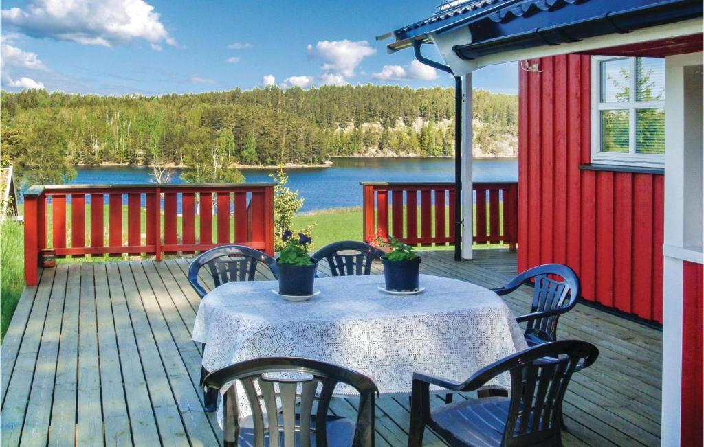 a table and chairs on a deck with a view of a lake at 3 Bedroom Cozy Home In Hemnes in Vortungen