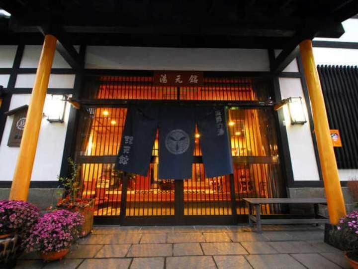 una puerta de entrada de un edificio con una bandera en él en Yakushi no Yu Yumotokan, en Kusatsu