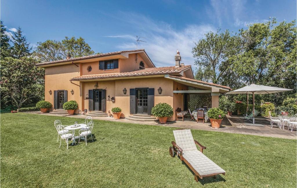 a house with a lawn with a table and chairs at Villa Loreto in Soriano nel Cimino