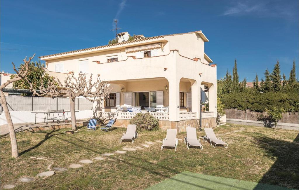 a house with lounge chairs in the yard at Roc De San Gaiet in Comarruga