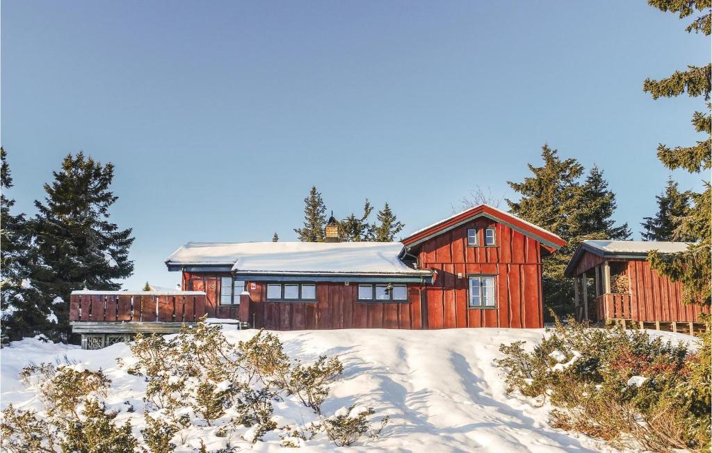 una casa roja en la nieve con árboles en 3 Bedroom Amazing Home In Sjusjen, en Sjusjøen
