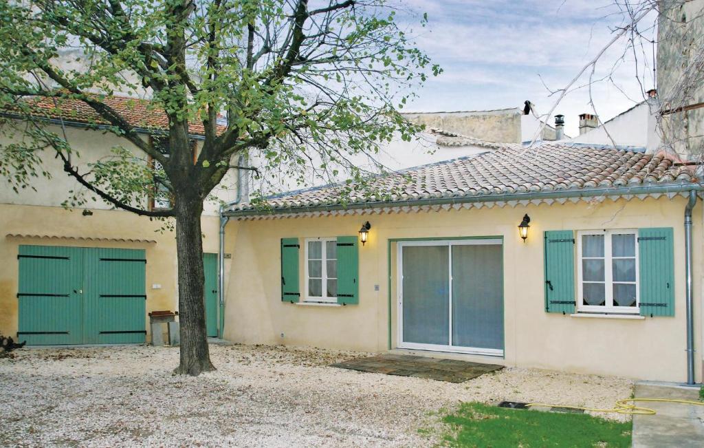 a house with green doors and a tree at Amazing Home In Suze La Rousse With 2 Bedrooms in Suze-la-Rousse