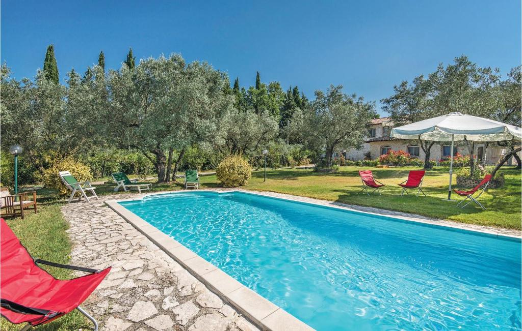 uma piscina com duas cadeiras vermelhas e um guarda-sol em Villa Laura em Monteleone Sabino