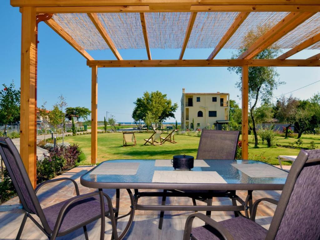 a table and chairs on a patio with a view of a park at Notos Resort - Tristinika Sithonia in Toroni