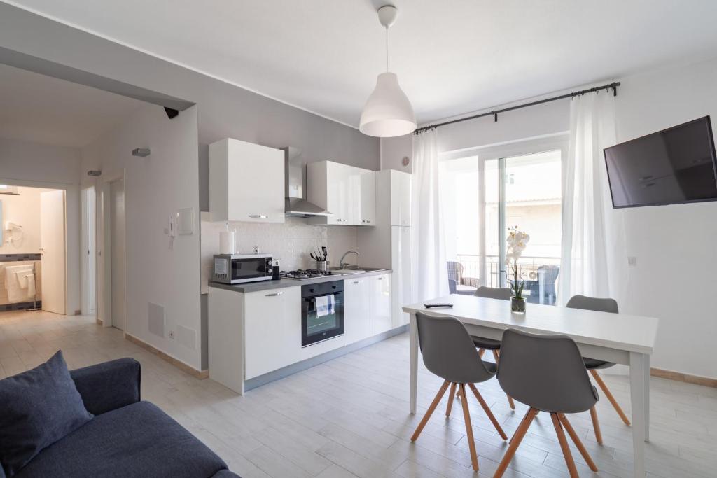 cocina y sala de estar con mesa y sillas en House 103 Rent Apartment, en Capo dʼOrlando