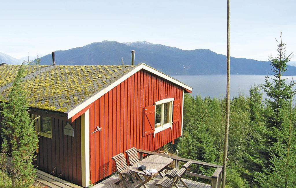 a red house with two chairs and a table at 3 Bedroom Amazing Home In Balestrand in Balestrand