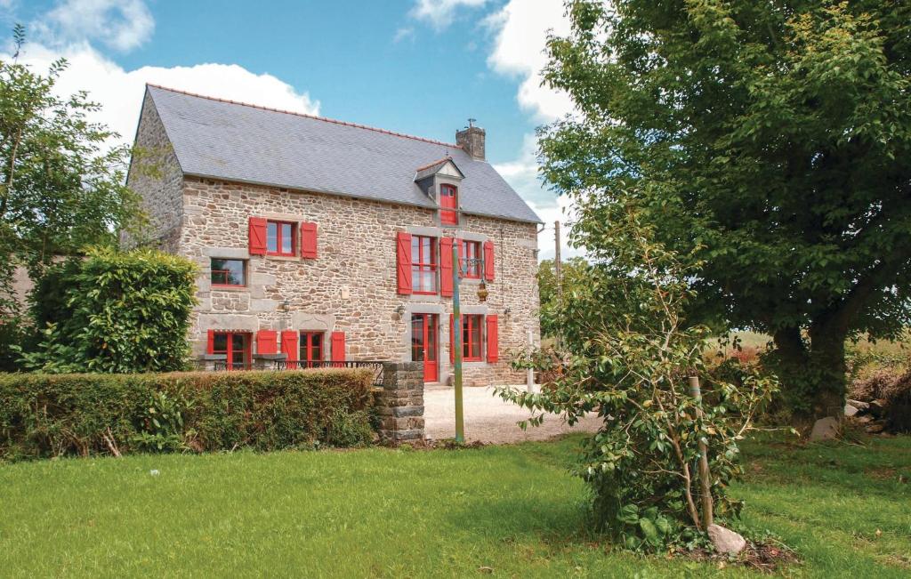 an old stone house with red windows and a tree at Gorgeous Home In Pleudihen Sur Rance in Mordreuc