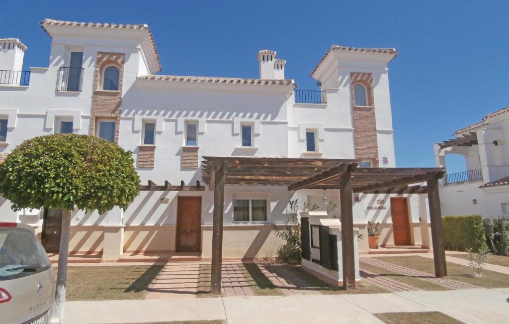 um grande edifício branco com toldo em frente em Beautiful Home In Roldn With Outdoor Swimming Pool em Roldán