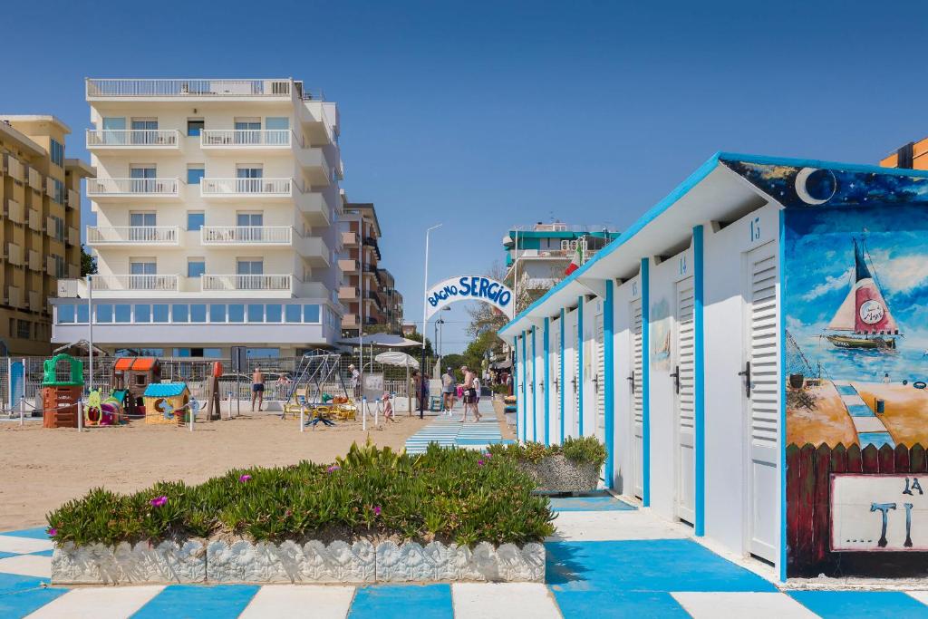 a building with a mural on it next to a beach at Hotel Ghirlandina in Rimini