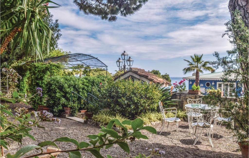 ogród ze stołem i krzesłami oraz szklarnią w obiekcie La Limonaia w mieście Ventimiglia