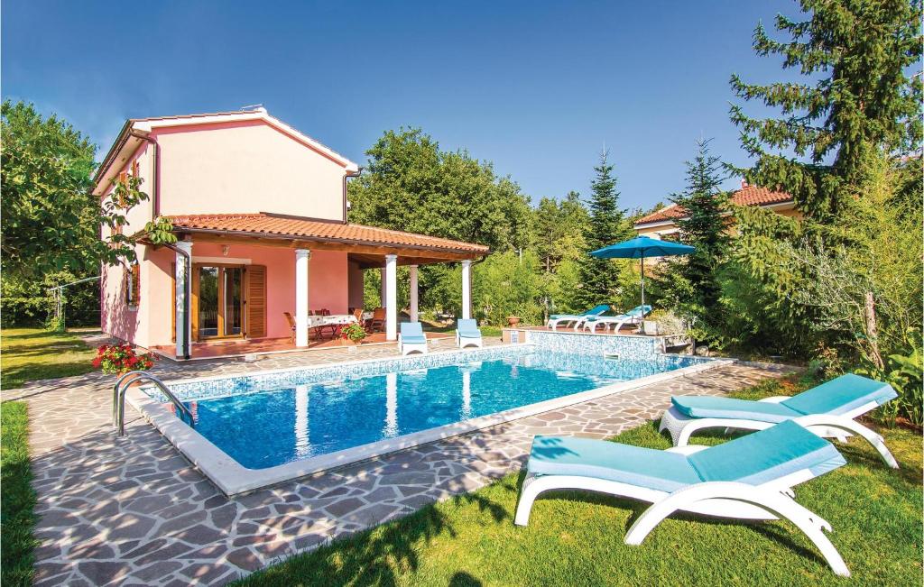 a swimming pool with chairs and a house at 4 Bedroom Beautiful Home In Laginji in Žminj