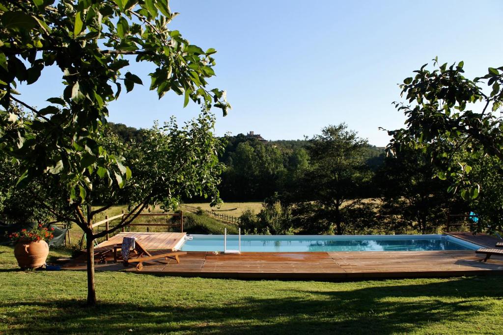 una piscina en un patio con terraza de madera en Centro Ippico Della Berardenga, en Castelnuovo Berardenga