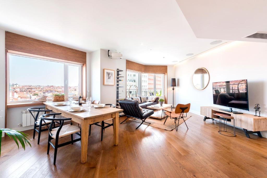 a living room with a wooden table and chairs at Genteel Home Plaza de España in Madrid