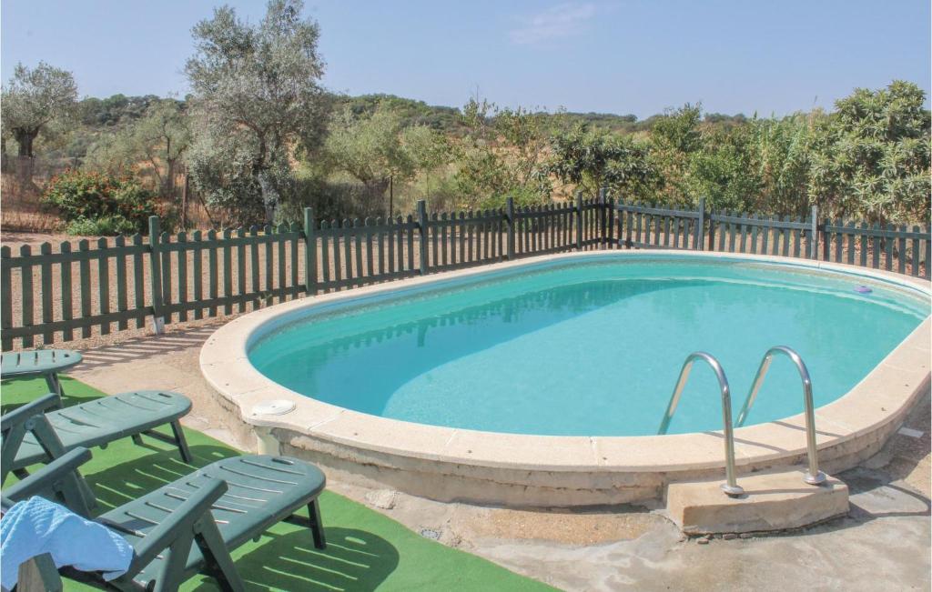 Villaviciosa de CórdobaにあるAwesome Home In Villaviciosa De Cordob With 3 Bedrooms, Wifi And Outdoor Swimming Poolのスイミングプール(椅子2脚、フェンス付)