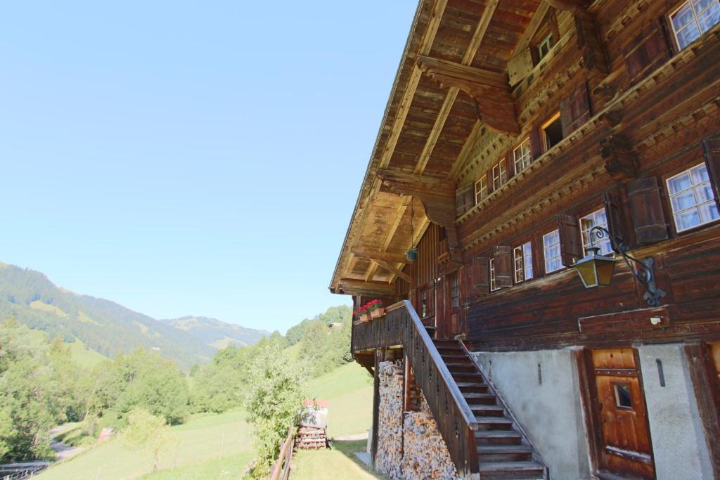 - un bâtiment en bois avec un escalier sur le côté dans l'établissement Les Favrod, à L'Etivaz