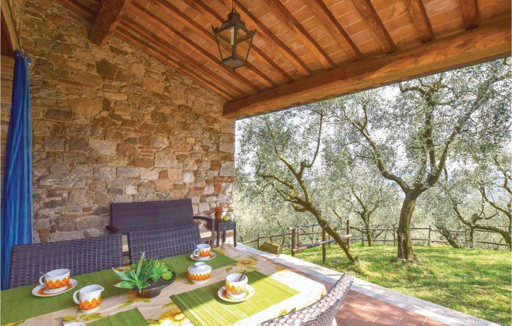 Un patio con mesa y sillas y un muro de piedra. en Parsilia, en Santa Maria Albiano