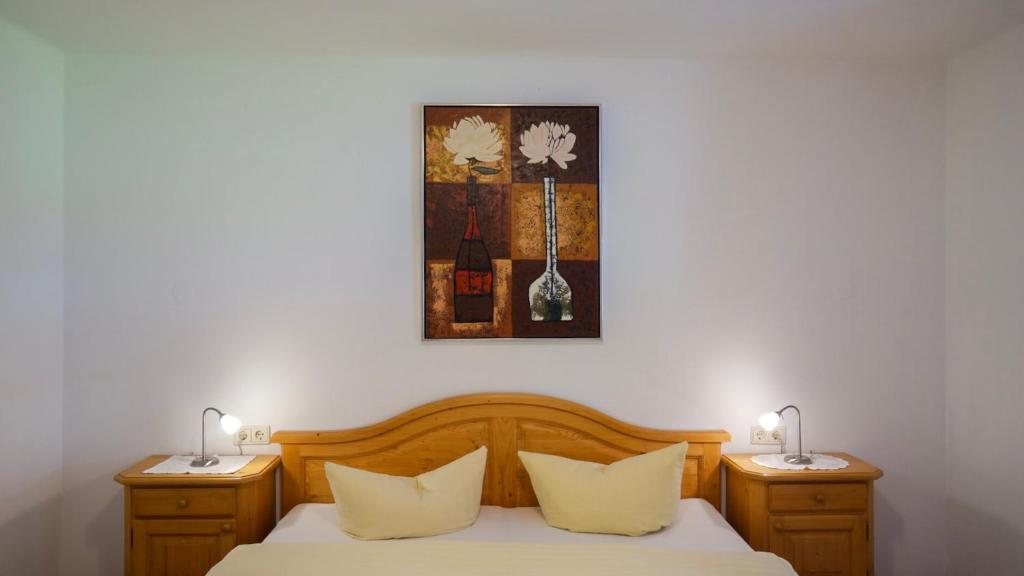 ein Schlafzimmer mit einem Bett mit zwei Nachttischen und zwei Lampen in der Unterkunft Apartment Ginzling in Mayrhofen
